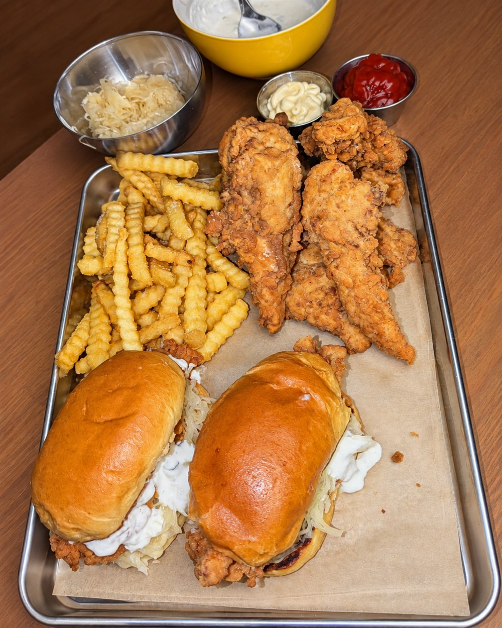 Ein erster Kochversuch: Chicken Fingers, zwei Burger und Pommes auf einem Metalltablett.
